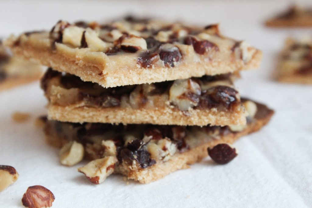 These Keto Shortbread cookies are layered with caramel and hazelnuts for the ultimate low-carb treat.  This recipe is included in my Complete Keto Holiday Cookbook, which is free, and releases 10/15/2018.