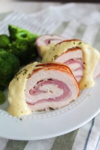 An easy and tasty family dinner, Bacon Wrapped Chicken Cordon Bleu.  Chicken breast is rolled up with ham, swiss cheese, and covered in bacon for the juiciest, tastiest chicken cordon bleu served with a homemade, ketogenic honey dijon cream sauce.