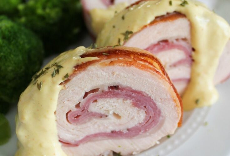 An easy and tasty family dinner, Bacon Wrapped Chicken Cordon Bleu.  Chicken breast is rolled up with ham, swiss cheese, and covered in bacon for the juiciest, tastiest chicken cordon bleu served with a homemade, ketogenic honey dijon cream sauce.