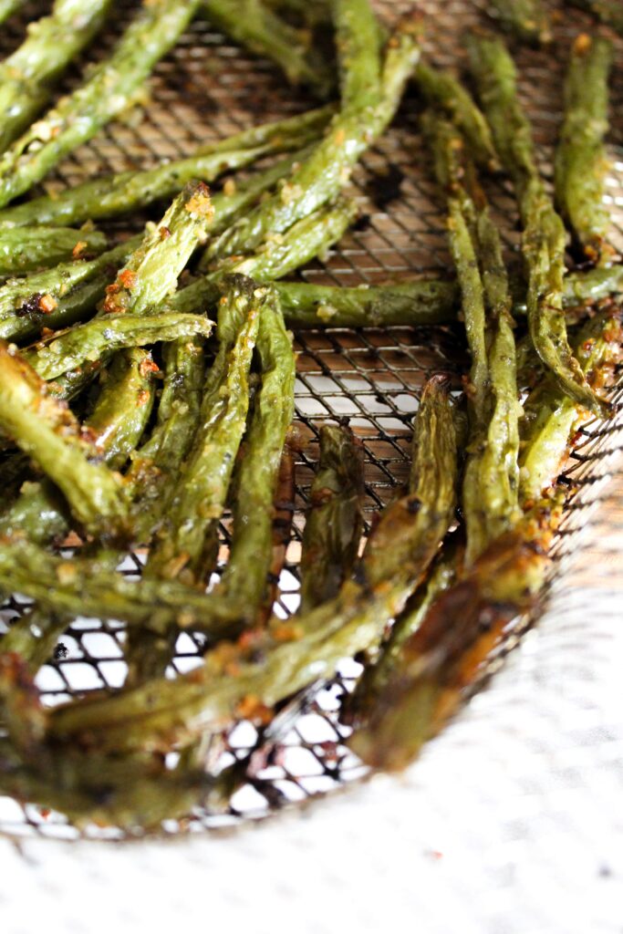 Green beans roasted in the oven take a long time and heat up the house, but Air Fryer Green Beans take less time, are crispy, and don't heat up the house.  They're very easy to make and are an excellent side dish that you can use many different herb combinations on!