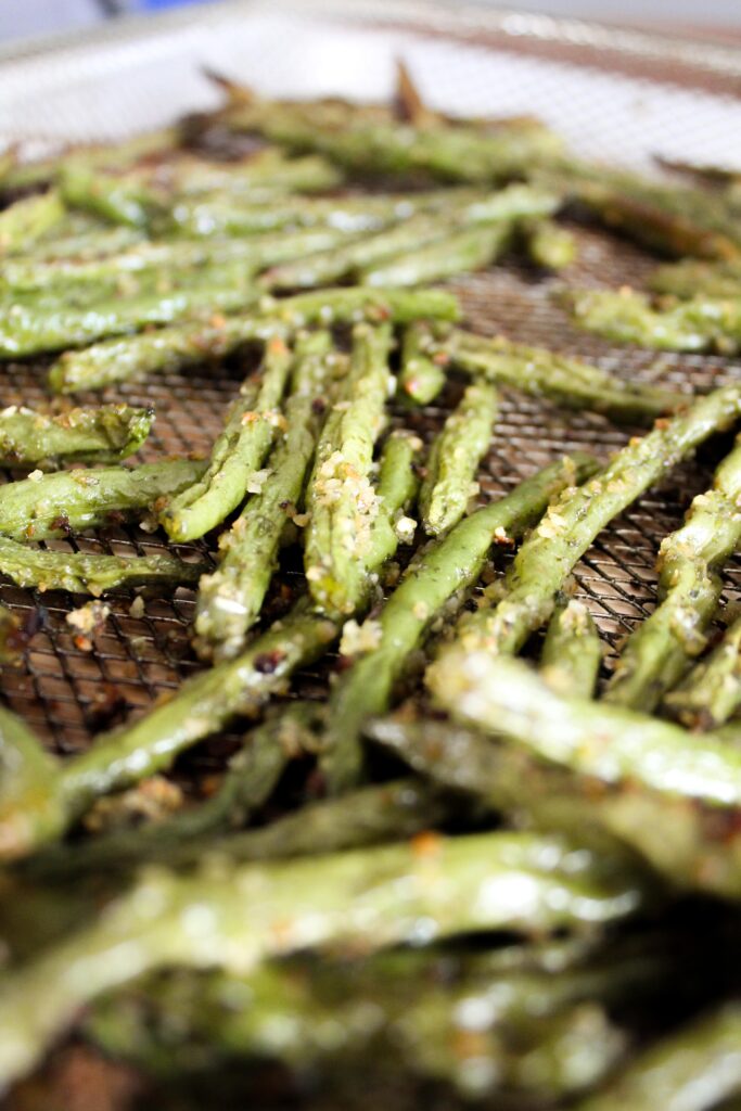 Green beans roasted in the oven take a long time and heat up the house, but Air Fryer Green Beans take less time, are crispy, and don't heat up the house.  They're very easy to make and are an excellent side dish that you can use many different herb combinations on!