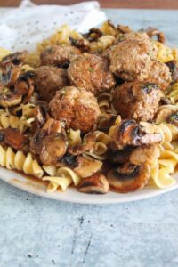 A Keto Salisbury Steak recipe - in meatball form - with mushroom gravy and ketogenic noodles.  Very easy to make and reheats well for weekday lunches.