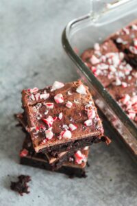 Classic Keto Fudge Brownies with peppermint extract and mint chocolate chips.  These Keto Peppermint Brownies are topped with fudge icing and crushed candy canes.