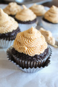 Creamy keto peanut butter icing tops rich dark chocolate cupcakes.   These delicious treats pack tons of flavor!