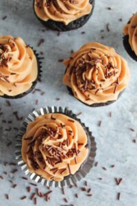 Creamy keto peanut butter icing tops rich dark chocolate cupcakes.   These delicious treats pack tons of flavor!