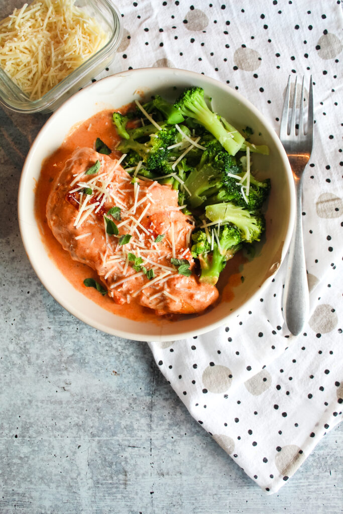 This super lazy but delicious meal is one you can throw in the slow cooker and let it to all the heavy lifting.  Browned chicken breasts in a creamy tomato sauce with basil and parmesan - delicious over many different vegetables for a keto-friendly dinner.