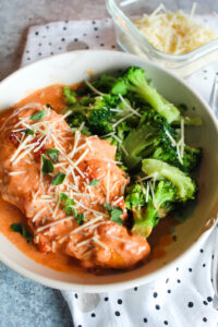 This super lazy but delicious meal is one you can throw in the slow cooker and let it to all the heavy lifting.  Browned chicken breasts in a creamy tomato sauce with basil and parmesan - delicious over many different vegetables for a keto-friendly dinner.