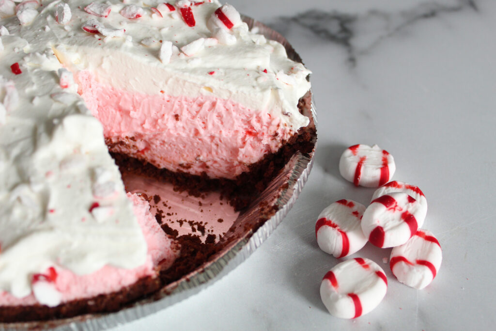A beautiful holiday or Valentine Dessert, Keto Peppermint Pie, aka Keto Candy Cane Pie uses cream cheese and whipped cream to create a fluffy dessert with a dark chocolate crust.  My family loves it, and yours will too!