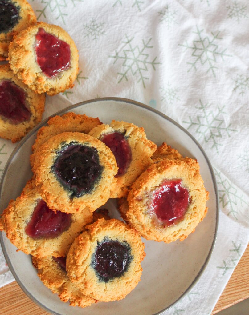 Soft shortbread cookies with a center of raspberry, blueberry, or apricot jam are Keto Thumbprint Cookie perfection.  A classic holiday treat!