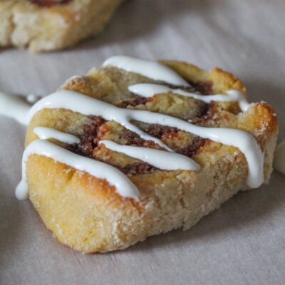 Keto Cinnamon Roll cookies are one of my favorite ways to repurpose keto sugar cookies into something cool!  Roll up the dough with a buttery sweet cinnamon filling, bake, and drizzle with vanilla icing.  The soften centers and slightly crisp outers mimic yeast cinnamon rolls - but without all the carbs and sugars!