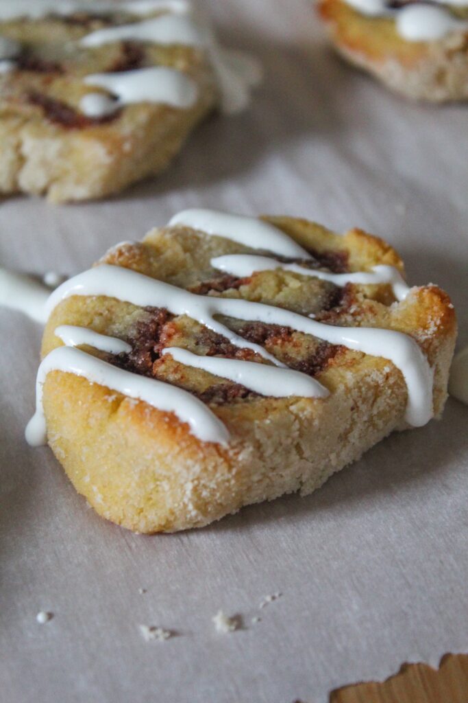 Keto Cinnamon Roll cookies are one of my favorite ways to repurpose keto sugar cookies into something cool!  Roll up the dough with a buttery sweet cinnamon filling, bake, and drizzle with vanilla icing.  The soft centers and slightly crisp outers mimic yeast cinnamon rolls - but without all the carbs and sugars!