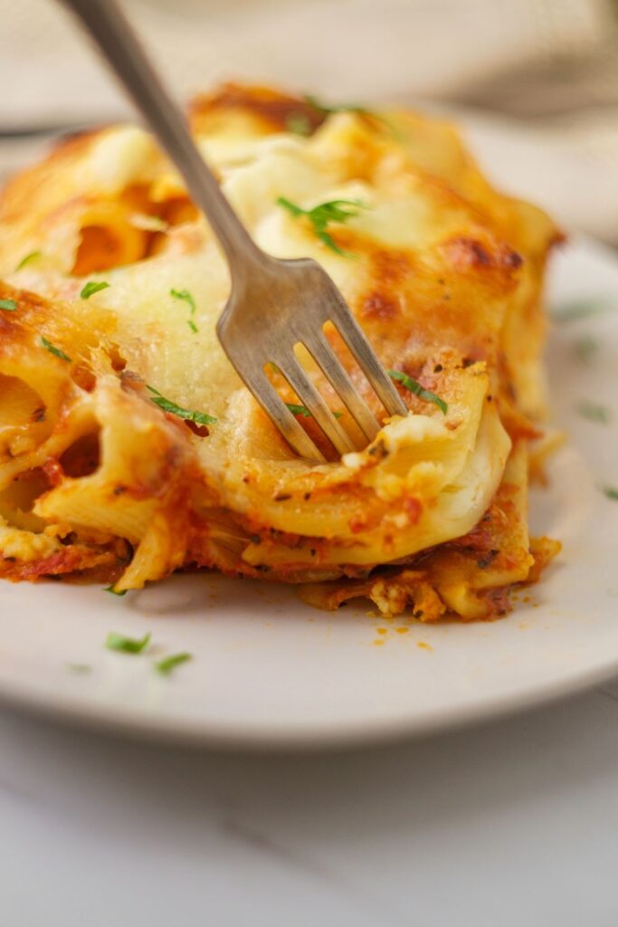 Keto baked ziti is a low carb twist on a classic recipe. You'll love how hearty and cheesy this comfort food dish is. Made with meat sauce, low carb noodles, and sugar free marinara, this is one of our favorite recipes for it's cheesy goodness!